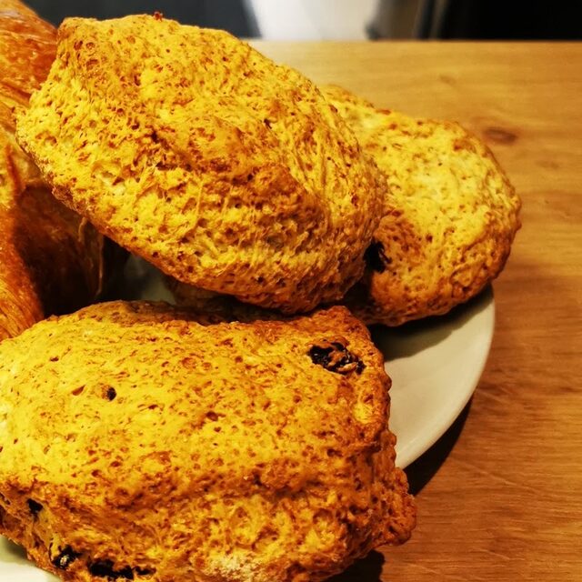 Scones on a white plate on a wooden counter